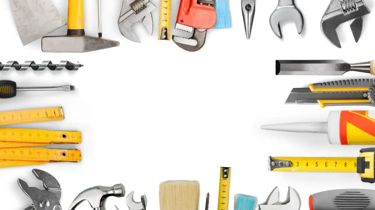 Diversas ferramentas manuais organizadas em torno de uma moldura em branco, incluindo martelos, chaves de fenda, pincéis, alicates, chaves inglesas, trenas, espátulas, estiletes, brocas e uma pistola de cola.