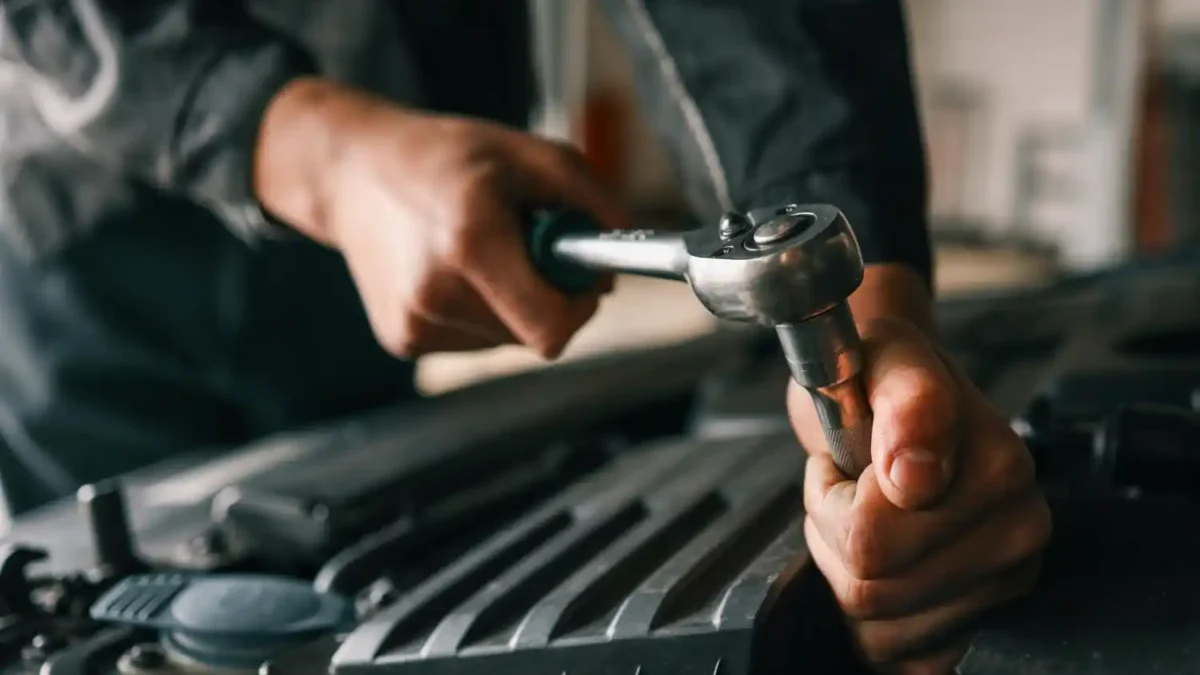 Profissional utilizando torquímetro para aplicar torque correto em componente automotivo