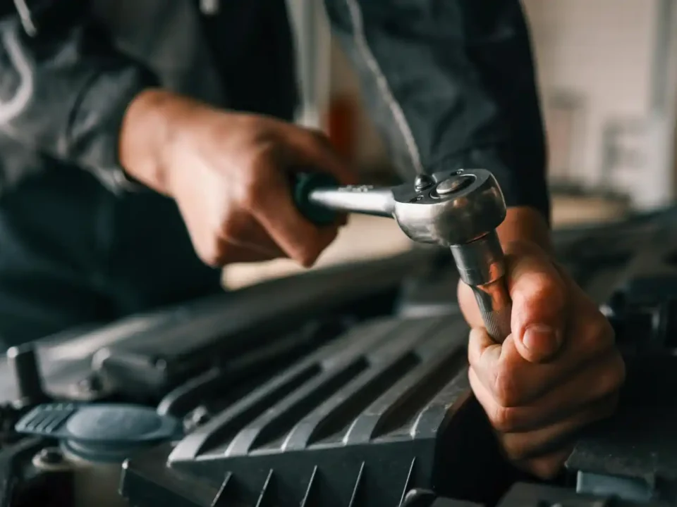 Profissional utilizando torquímetro para aplicar torque correto em componente automotivo
